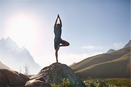 simsearch:614-08869222,k - Young man balancing in tree pose on rock in sunny, remote valley Stock Photo - Premium Royalty-Free, Code: 6113-08882844