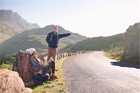 simsearch:649-03769219,k - Young couple hitchhiking at sunny, remote roadside Fotografie stock - Premium Royalty-Free, Codice: 6113-08882833