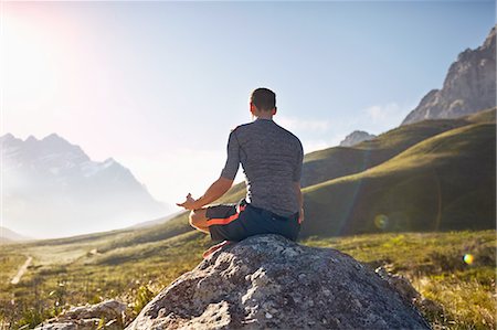 simsearch:6113-08655494,k - Young man meditating on rock in sunny, remote valley Stock Photo - Premium Royalty-Free, Code: 6113-08882838