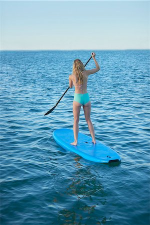 simsearch:6113-08805299,k - Young woman in bikini paddleboarding in summer ocean Stock Photo - Premium Royalty-Free, Code: 6113-08805289