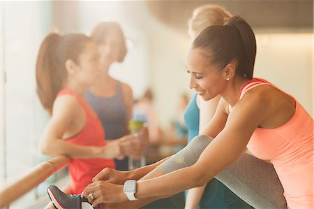 simsearch:6113-09058385,k - Woman tying shoe at barre in exercise class gym studio Foto de stock - Sin royalties Premium, Código: 6113-08805376