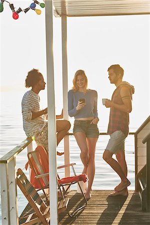 simsearch:6113-08568592,k - Young adult friends hanging out on sunny summer houseboat Foto de stock - Sin royalties Premium, Código: 6113-08805300