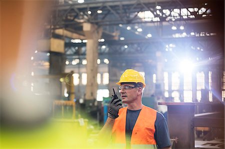 factory lights - Steel worker using walkie-talkie in factory Foto de stock - Sin royalties Premium, Código: 6113-08805546