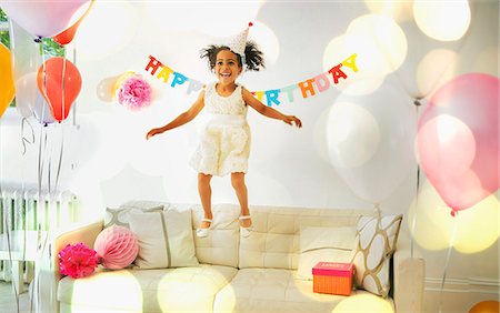 Playful girl jumping on sofa Photographie de stock - Premium Libres de Droits, Code: 6113-08805646