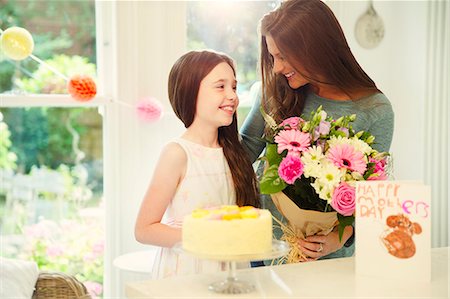 Affectionate daughter giving flower bouquet to mother on Mother's Day Stock Photo - Premium Royalty-Free, Code: 6113-08805664