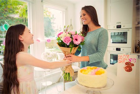 smiling woman with a child - Affectionate daughter giving flower bouquet to mother on Mother's Day Stock Photo - Premium Royalty-Free, Code: 6113-08805670