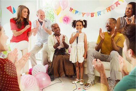 simsearch:6113-08882583,k - Multi-ethnic family clapping for girl singing karaoke with microphone at birthday party Photographie de stock - Premium Libres de Droits, Code: 6113-08805687