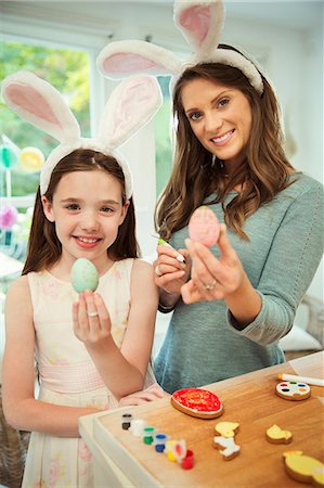 Portrait smiling mother and daughter wearing costume rabbit ears showing decorated Easter eggs Stock Photo - Premium Royalty-Free, Code: 6113-08805689