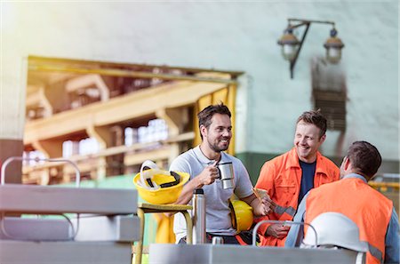 Smiling steel workers enjoying coffee break ins factory Photographie de stock - Premium Libres de Droits, Code: 6113-08805616