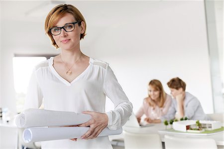 simsearch:6124-08768389,k - Portrait confident female architect holding blueprints in conference room Stock Photo - Premium Royalty-Free, Code: 6113-08805764