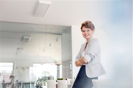 simsearch:6113-08805775,k - Portrait smiling businesswoman in conference room Foto de stock - Sin royalties Premium, Código: 6113-08805788