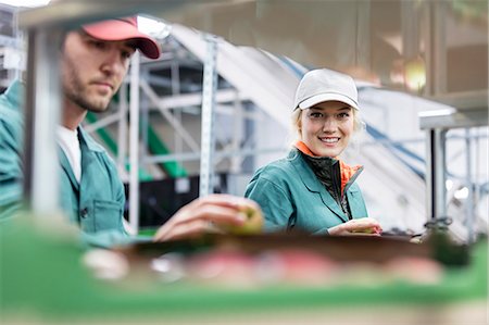examining food - Portrait smiling female worker inspecting apples in food processing plant Photographie de stock - Premium Libres de Droits, Code: 6113-08805797