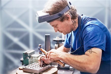 design tools - Focused jeweler using hammer in workshop Stock Photo - Premium Royalty-Free, Code: 6113-08805705