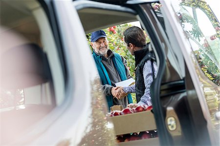 Male farmer and customer handshaking at truck in apple orchard Foto de stock - Sin royalties Premium, Código: 6113-08805805