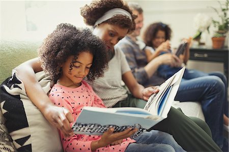 simsearch:6113-07543284,k - Parents reading books with daughters on living room sofa Stock Photo - Premium Royalty-Free, Code: 6113-08943572