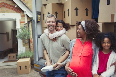 piggyback ride sister - Portrait smiling pregnant multi-ethnic young family moving into new house Stock Photo - Premium Royalty-Free, Code: 6113-08943578
