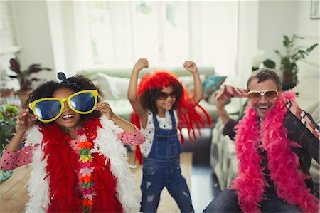 simsearch:649-06401447,k - Playful multi-ethnic father and daughters playing dress up with oversized sunglasses and feather boas Photographie de stock - Premium Libres de Droits, Code: 6113-08943588