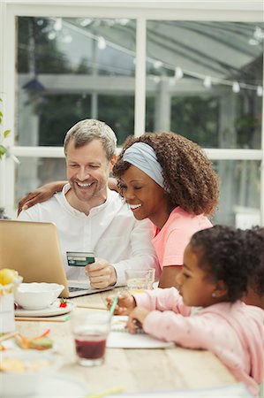 family shopping not groceries - Multi-ethnic young family online shopping with credit card at laptop Foto de stock - Sin royalties Premium, Código: 6113-08943591
