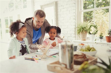 Multi-ethnic father and daughters coloring in kitchen Stock Photo - Premium Royalty-Free, Code: 6113-08943648