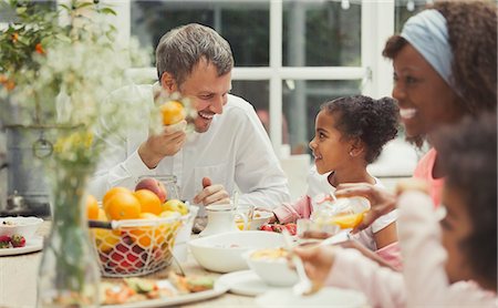 simsearch:6113-08943670,k - Multi-ethnic father and daughter eating breakfast at table Stock Photo - Premium Royalty-Free, Code: 6113-08943658