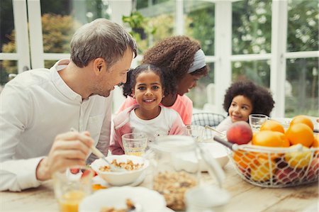 simsearch:614-08329300,k - Portrait smiling multi-ethnic young family eating breakfast at table Photographie de stock - Premium Libres de Droits, Code: 6113-08943609