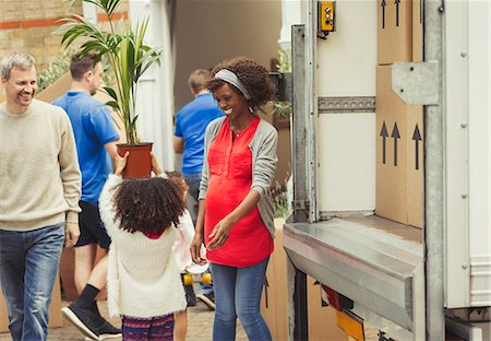 Multi-ethnic young family unloading moving van outside new house Stock Photo - Premium Royalty-Free, Code: 6113-08943612