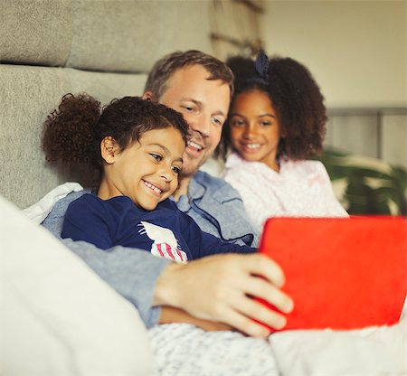 simsearch:649-06716996,k - Multi-ethnic father and daughters using digital tablet on bed Stock Photo - Premium Royalty-Free, Code: 6113-08943626