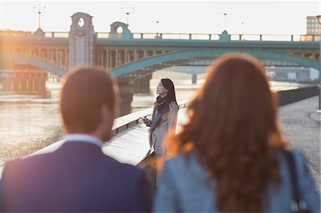 Businesswoman with cell phone at urban waterfront Stock Photo - Premium Royalty-Free, Code: 6113-08943746