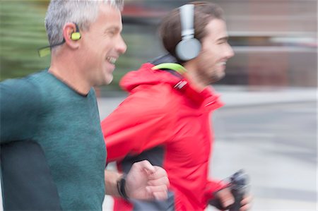 side view male joggers - Smiling male runners with headphones running Stock Photo - Premium Royalty-Free, Code: 6113-08943774