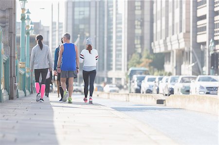 Runners walking on sunny urban city sidewalk Stock Photo - Premium Royalty-Free, Code: 6113-08943703