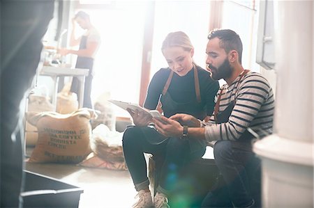 Coffee roasters meeting, looking at clipboard and cell phone Stock Photo - Premium Royalty-Free, Code: 6113-08943860