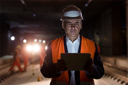 Serious male foreman using digital tablet at dark construction site Foto de stock - Sin royalties Premium, Código: 6113-08943890