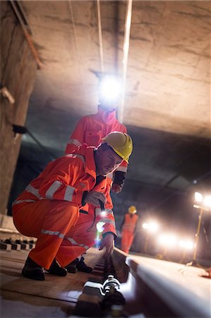 souterrain - Male construction workers examining underground tracks at dark construction site Photographie de stock - Premium Libres de Droits, Code: 6113-08943897