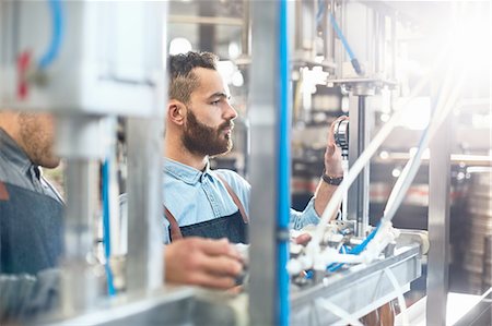 simsearch:6118-08761911,k - Male brewer adjusting dial on bottling machine in brewery Foto de stock - Sin royalties Premium, Código: 6113-08943839