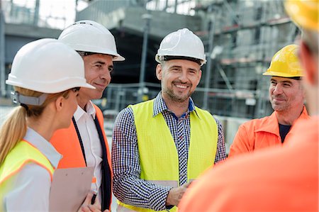 Smiling engineers and construction workers meeting at construction site Stock Photo - Premium Royalty-Free, Code: 6113-08943950