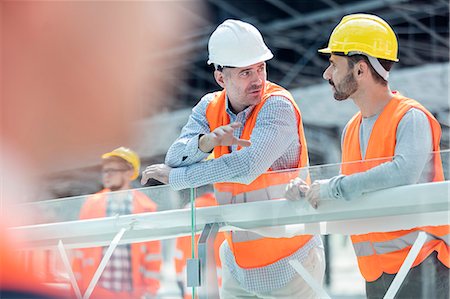 Male foreman and construction worker talking at construction site Fotografie stock - Premium Royalty-Free, Codice: 6113-08943900