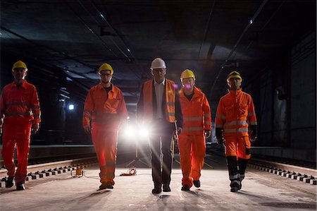 railway - Male foreman and construction workers walking in dark construction site underground Foto de stock - Sin royalties Premium, Código: 6113-08943901