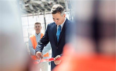 ribbon (material) - Businessman cutting ribbon at new construction site ceremony Foto de stock - Sin royalties Premium, Código: 6113-08943916