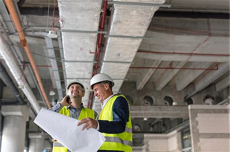 smiling blue collar guy - Male engineers with flashlight and blueprints at construction site Stock Photo - Premium Royalty-Free, Code: 6113-08943934