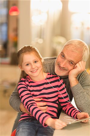 simsearch:6113-07242899,k - Portrait smiling father and daughter bonding, sharing headphones and using digital tablet Stock Photo - Premium Royalty-Free, Code: 6113-08947246
