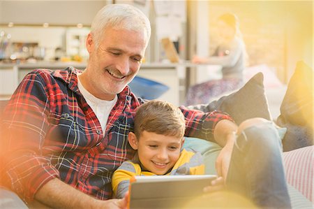 simsearch:6113-07242899,k - Father and son bonding, sharing digital tablet on sofa Stock Photo - Premium Royalty-Free, Code: 6113-08947259