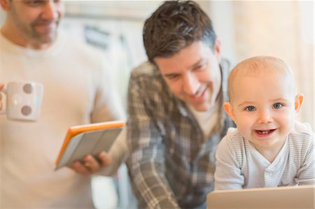 Portrait cute baby son with male gay parents using digital tablet Stock Photo - Premium Royalty-Free, Code: 6113-08947282