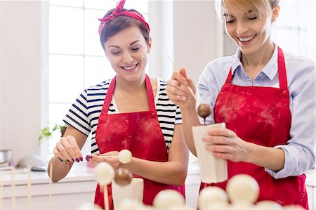simsearch:6113-08947344,k - Smiling female caterers making cake pops in kitchen Stock Photo - Premium Royalty-Free, Code: 6113-08947344