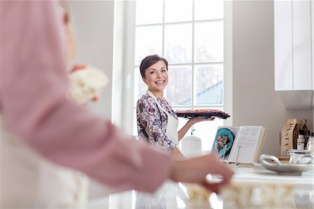 Smiling woman baking in kitchen Stock Photo - Premium Royalty-Free, Code: 6113-08947358