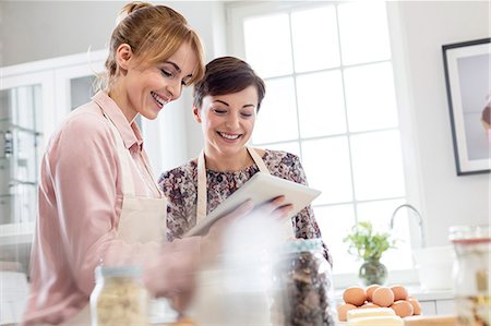 Smiling female caterers using digital tablet, baking in kitchen Photographie de stock - Premium Libres de Droits, Code: 6113-08947367