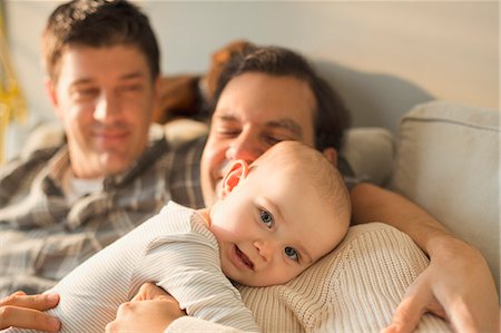 Portrait cute baby son cuddling with male gay parents Stock Photo - Premium Royalty-Free, Code: 6113-08947334