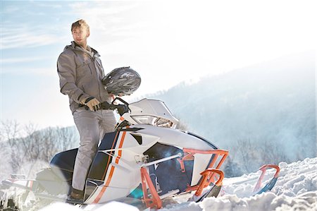 simsearch:6113-08947434,k - Man riding snowmobile in sunny snowy field Stock Photo - Premium Royalty-Free, Code: 6113-08947431