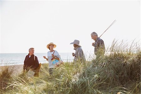 simsearch:6113-07589328,k - Senior couples with fishing pole walking in sunny beach grass Stock Photo - Premium Royalty-Free, Code: 6113-08985687