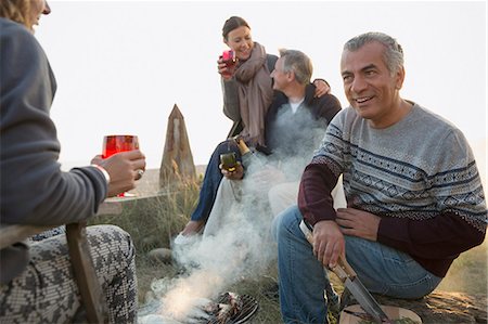 Mature couples drinking wine and barbecuing on beach Photographie de stock - Premium Libres de Droits, Code: 6113-08985743