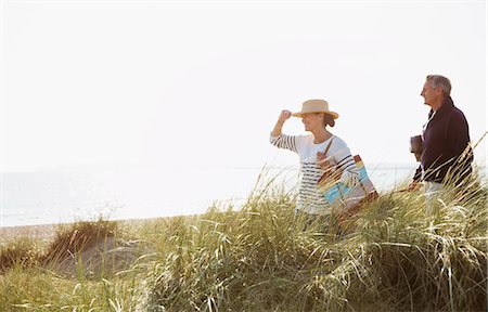 simsearch:6113-08985723,k - Mature couple walking in sunny beach grass Stock Photo - Premium Royalty-Free, Code: 6113-08985744